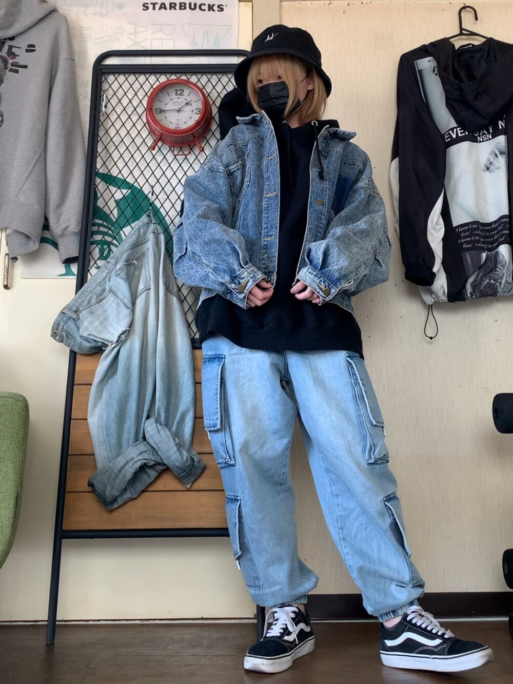 ブルー系のデニムジャケット、ブルー系のデニムパンツ、ブラック系のパーカーを着用したレディースの春コーディネートの4枚目の写真