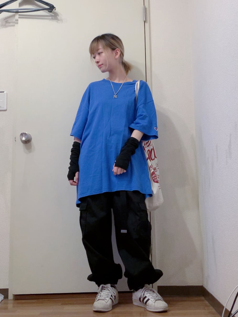 ブルー系のTシャツ/カットソー、ブラック系のカーゴパンツ、ホワイト系のスニーカーを着用したレディースの夏コーディネートの2枚目の写真
