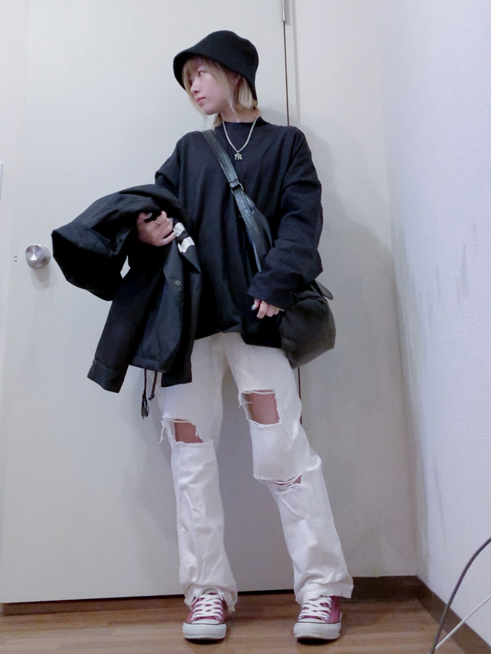 ブラック系のTシャツ/カットソー、ホワイト系のデニムパンツ、レッド系のスニーカーを着用したレディースの秋コーディネートの2枚目の写真