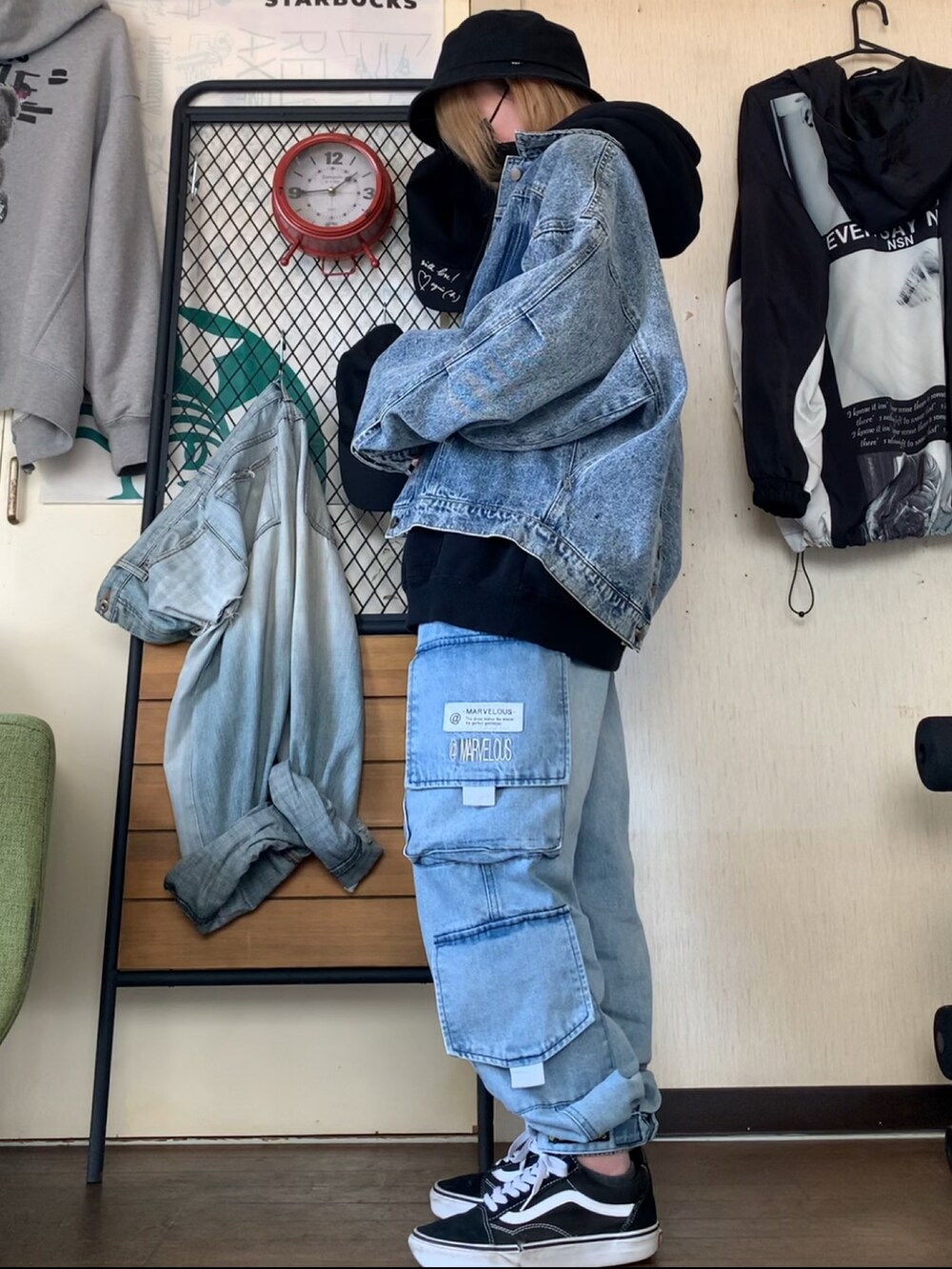 ブルー系のデニムジャケット、ブルー系のデニムパンツ、ブラック系のパーカーを着用したレディースの春コーディネートの3枚目の写真