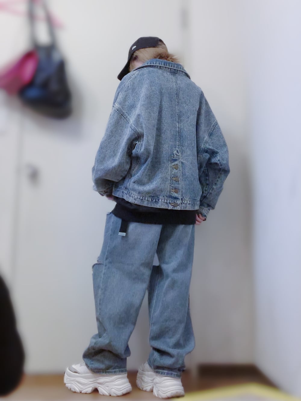 ブラック系のスウェット、ブルー系のデニムジャケット、ブルー系のデニムパンツを着用したレディースの春コーディネートの3枚目の写真