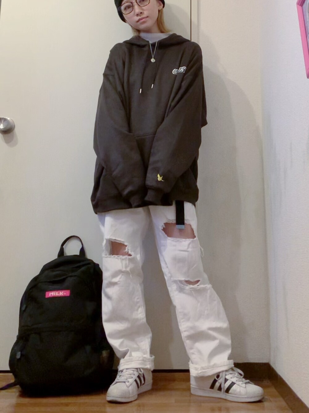 ブラック系のパーカー、ホワイト系のデニムパンツ、ホワイト系のニット/セーターを着用したレディースの冬コーディネートの3枚目の写真