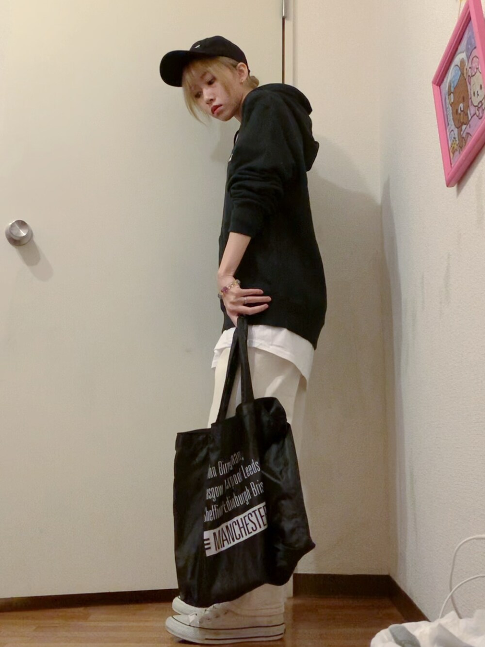 ブラック系のパーカー、ホワイト系のデニムパンツ、ホワイト系のスニーカーを着用したレディースの春コーディネートの3枚目の写真