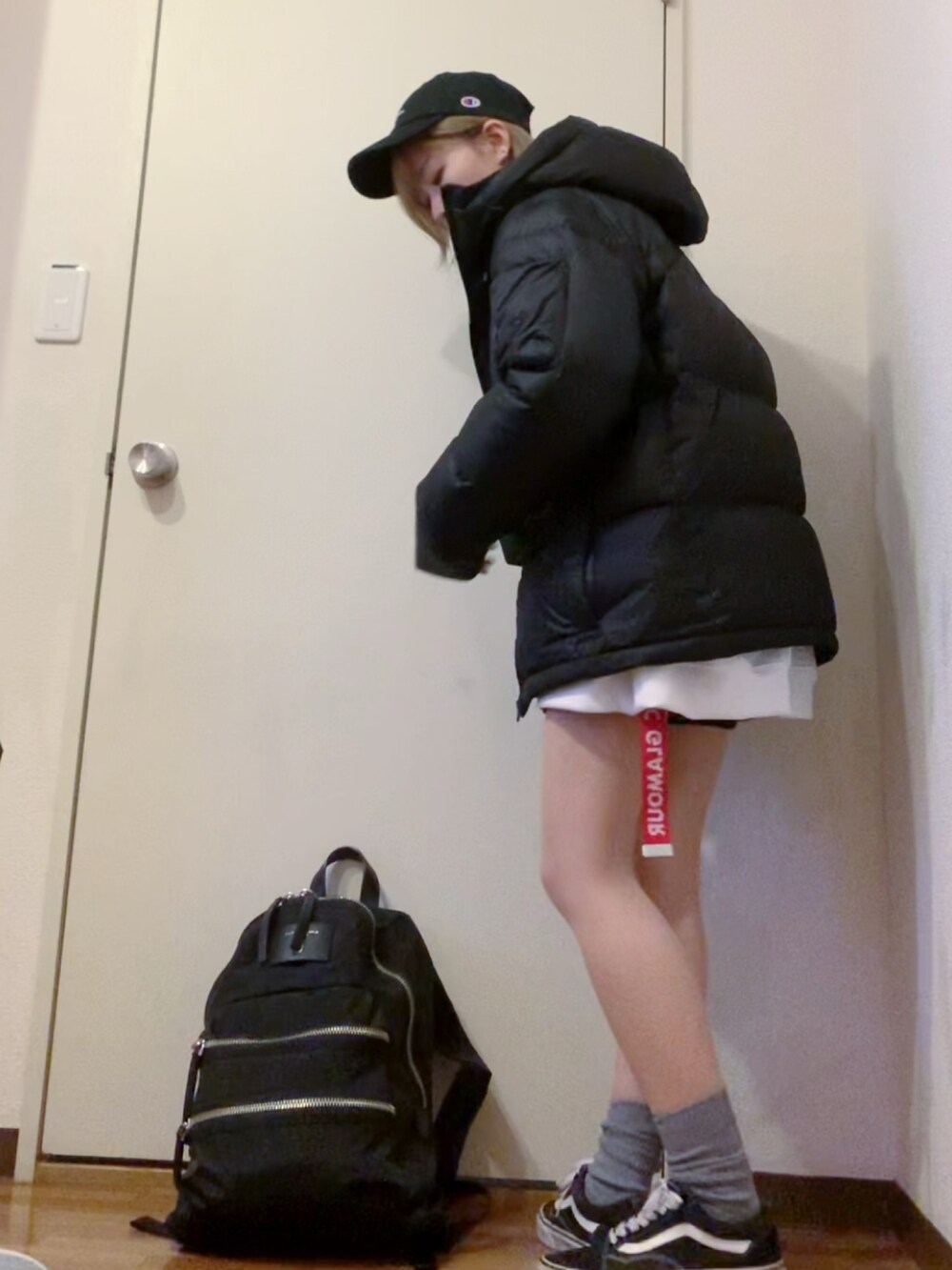 ホワイト系のスウェット、ブラック系のデニムパンツ、ブラック系のスニーカーを着用したレディースの冬コーディネートの4枚目の写真