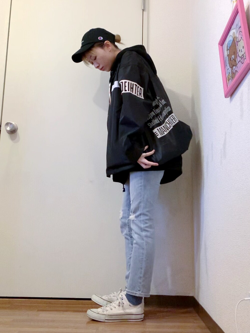 ブラック系のナイロンジャケット、ブラック系のパーカー、ブルー系のデニムパンツを着用したレディースの春コーディネートの3枚目の写真