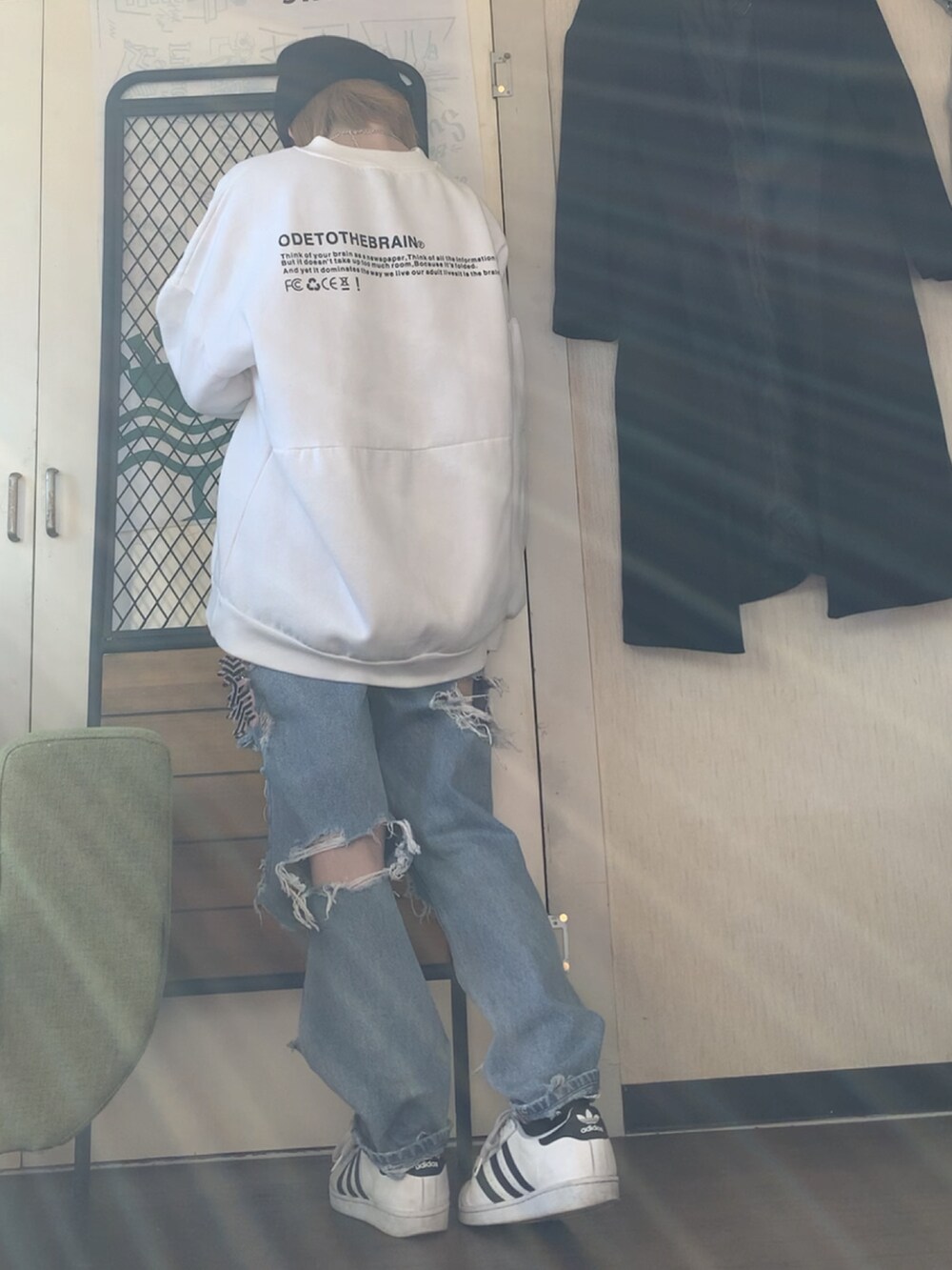 グレー系のチェスターコート、ホワイト系のスウェット、ブルー系のデニムパンツを着用したレディースの冬コーディネートの4枚目の写真