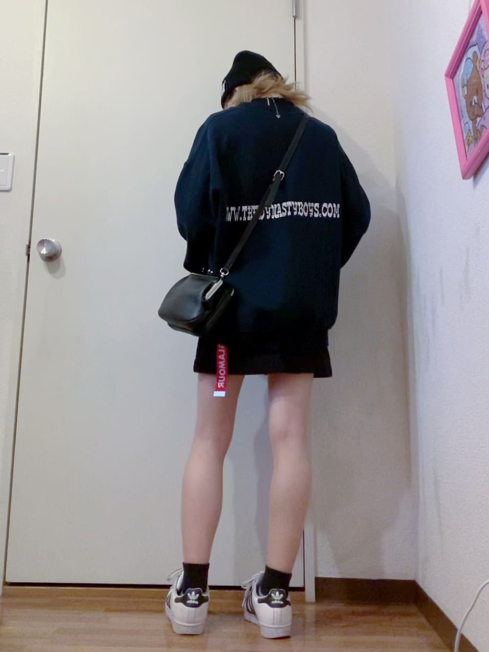 ブラック系のスウェット、ブラック系のスカート、ブラック系のナイロンジャケットを着用したレディースの春コーディネートの2枚目の写真