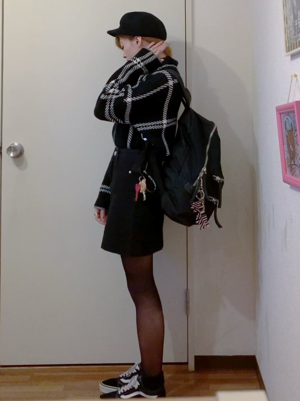 ブラック系のニット/セーター、ブラック系のスカート、ブラック系のスニーカーを着用したレディースの秋コーディネートの2枚目の写真