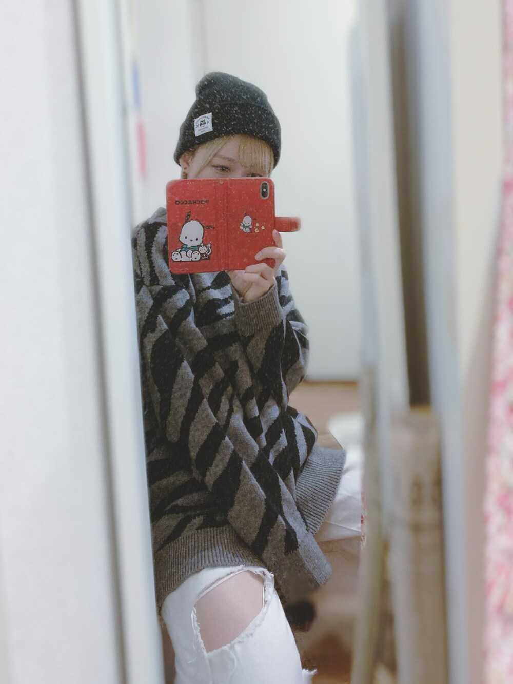 グレー系のニット/セーター、ホワイト系のデニムパンツ、ブラック系のスニーカーを着用したレディースの秋コーディネートの3枚目の写真