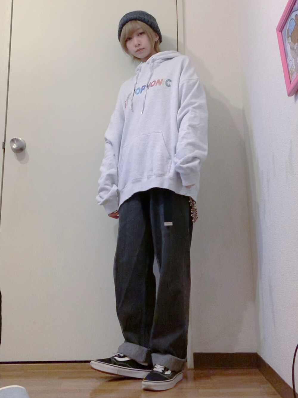 グレー系のパーカー、ブラック系のデニムパンツ、ブラック系のチェスターコートを着用したレディースの冬コーディネートの4枚目の写真