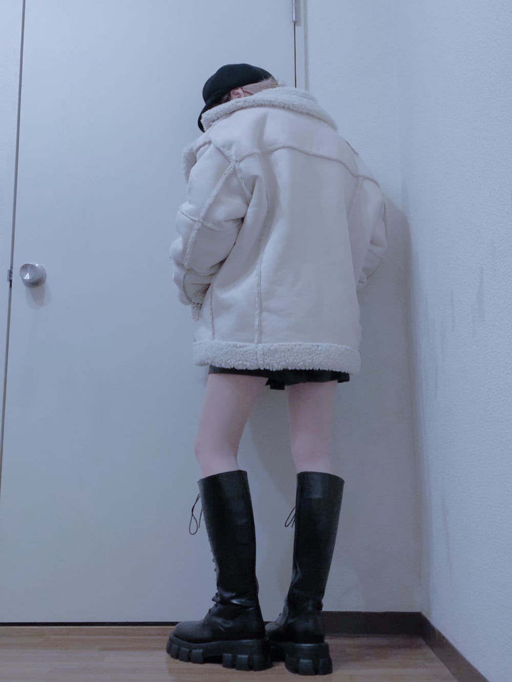 ホワイト系のムートンコート、ホワイト系のニット/セーター、ブラック系のその他パンツを着用したレディースの冬コーディネートの2枚目の写真