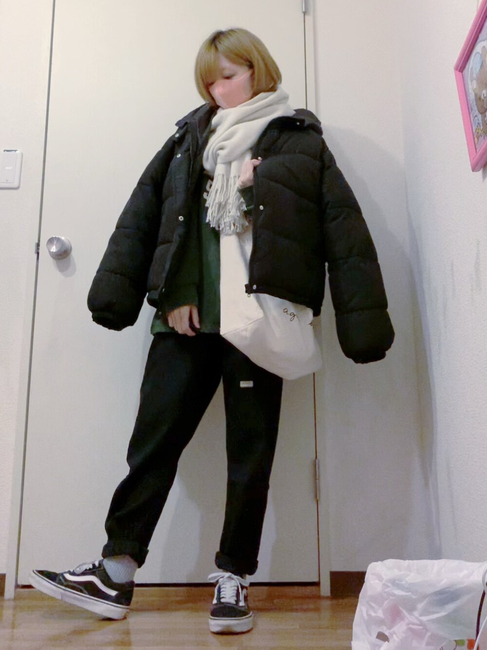 グリーン系のスウェット、ブラック系のデニムパンツ、ブラック系のスニーカーを着用したレディースの冬コーディネートの3枚目の写真