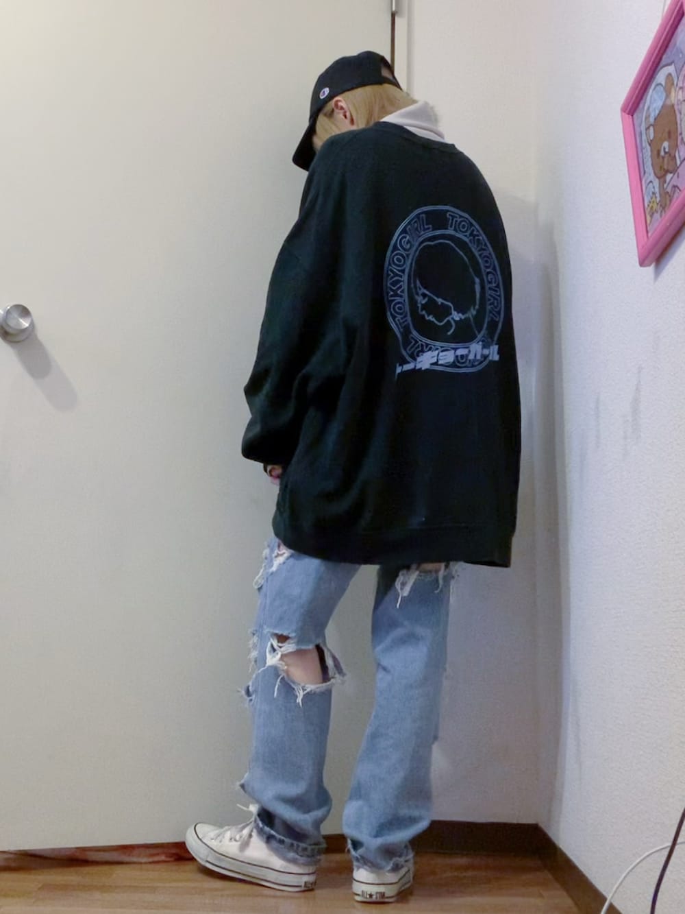 ブラック系のスウェット、ホワイト系のニット/セーター、ブルー系のデニムパンツを着用したレディースの冬コーディネートの3枚目の写真