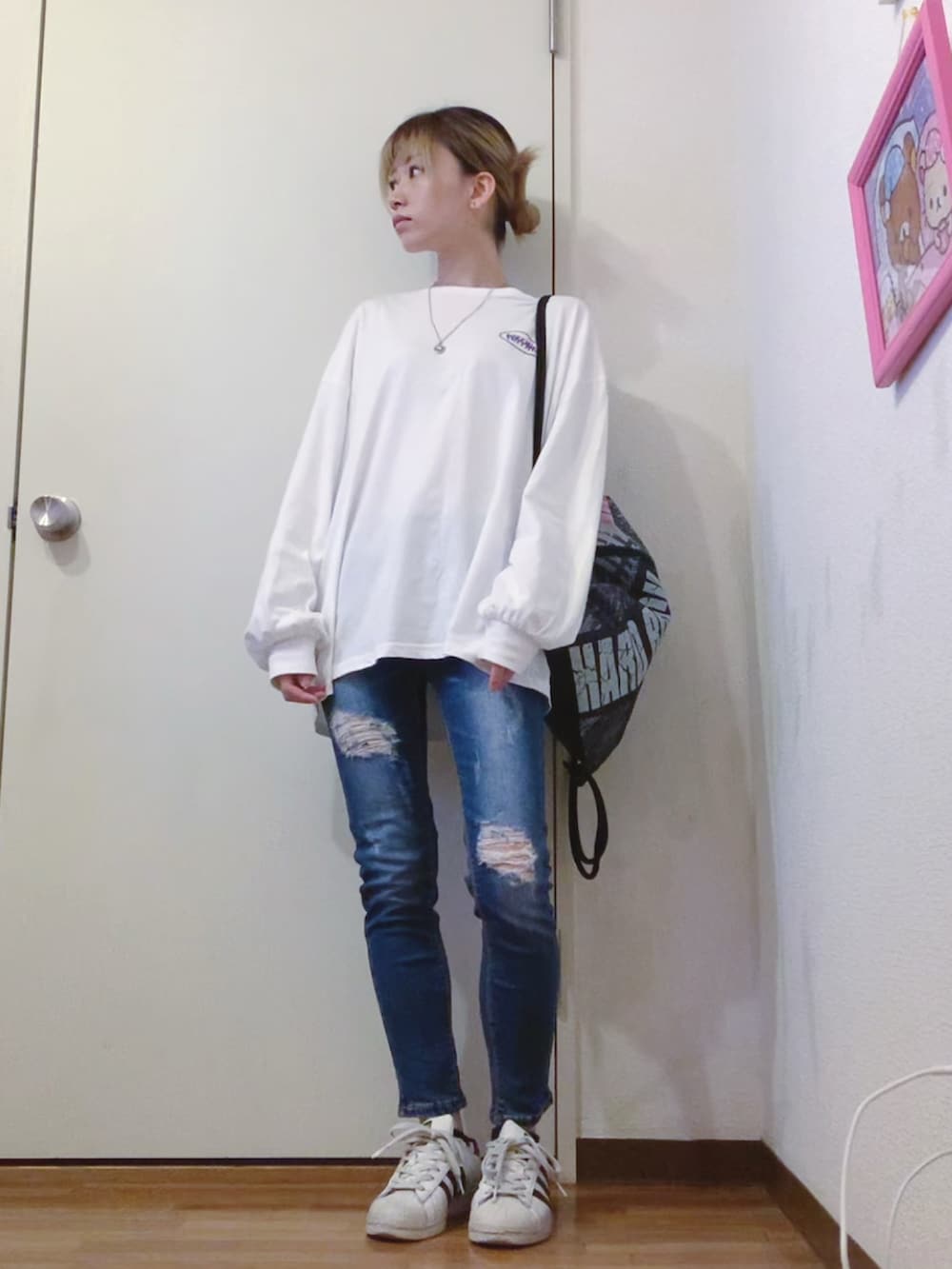 ホワイト系のTシャツ/カットソー、ブルー系のデニムパンツ、ブラック系のバックパック/リュックを着用したレディースの春コーディネートの2枚目の写真