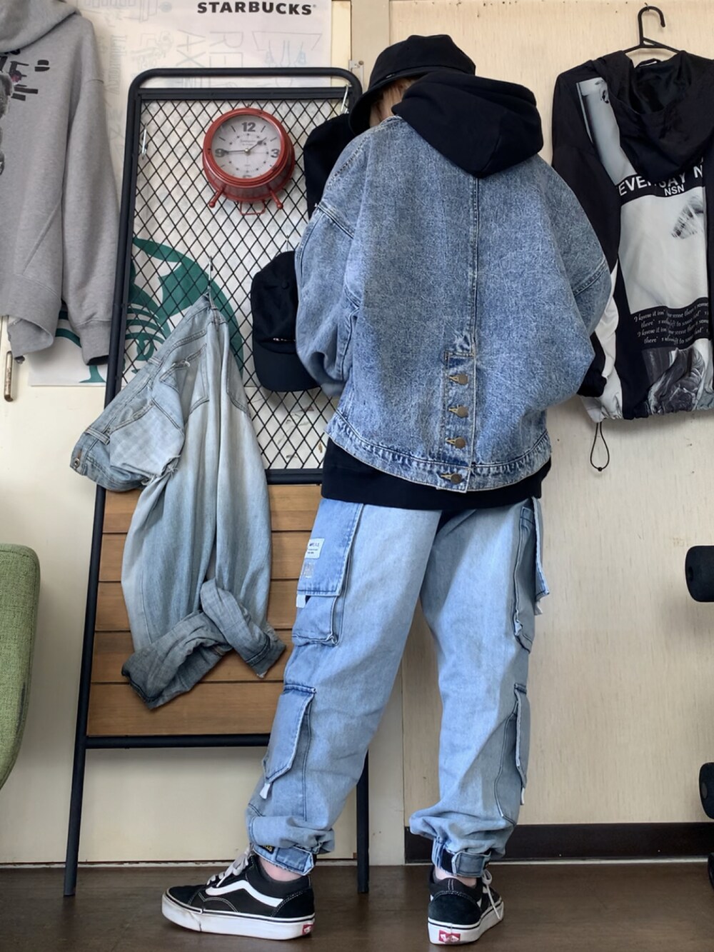 ブルー系のデニムジャケット、ブルー系のデニムパンツ、ブラック系のパーカーを着用したレディースの春コーディネートの2枚目の写真