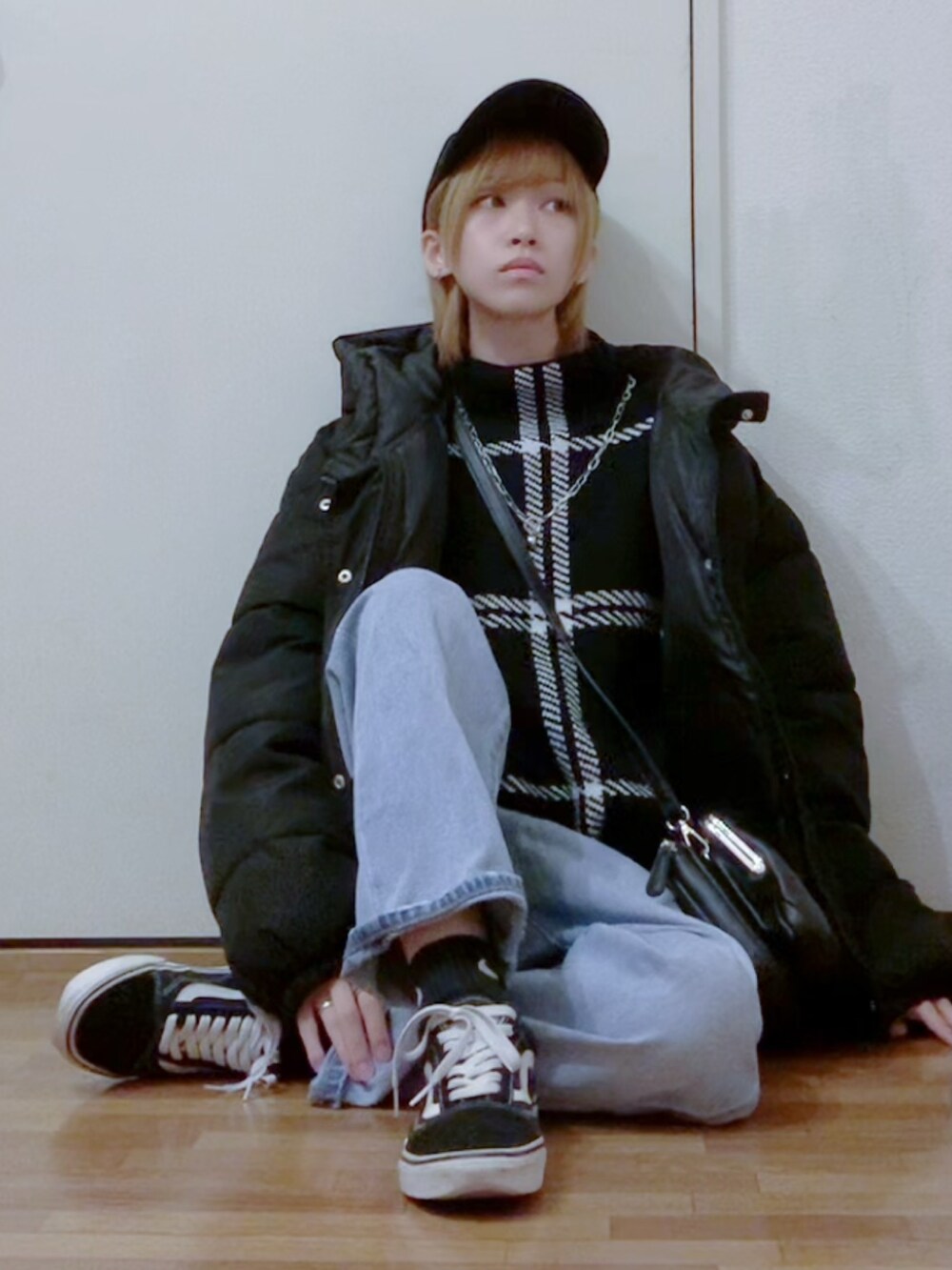 ブラック系のニット/セーター、ブルー系のデニムパンツ、ブラック系のダウンジャケット/コートを着用したレディースの秋コーディネートの3枚目の写真