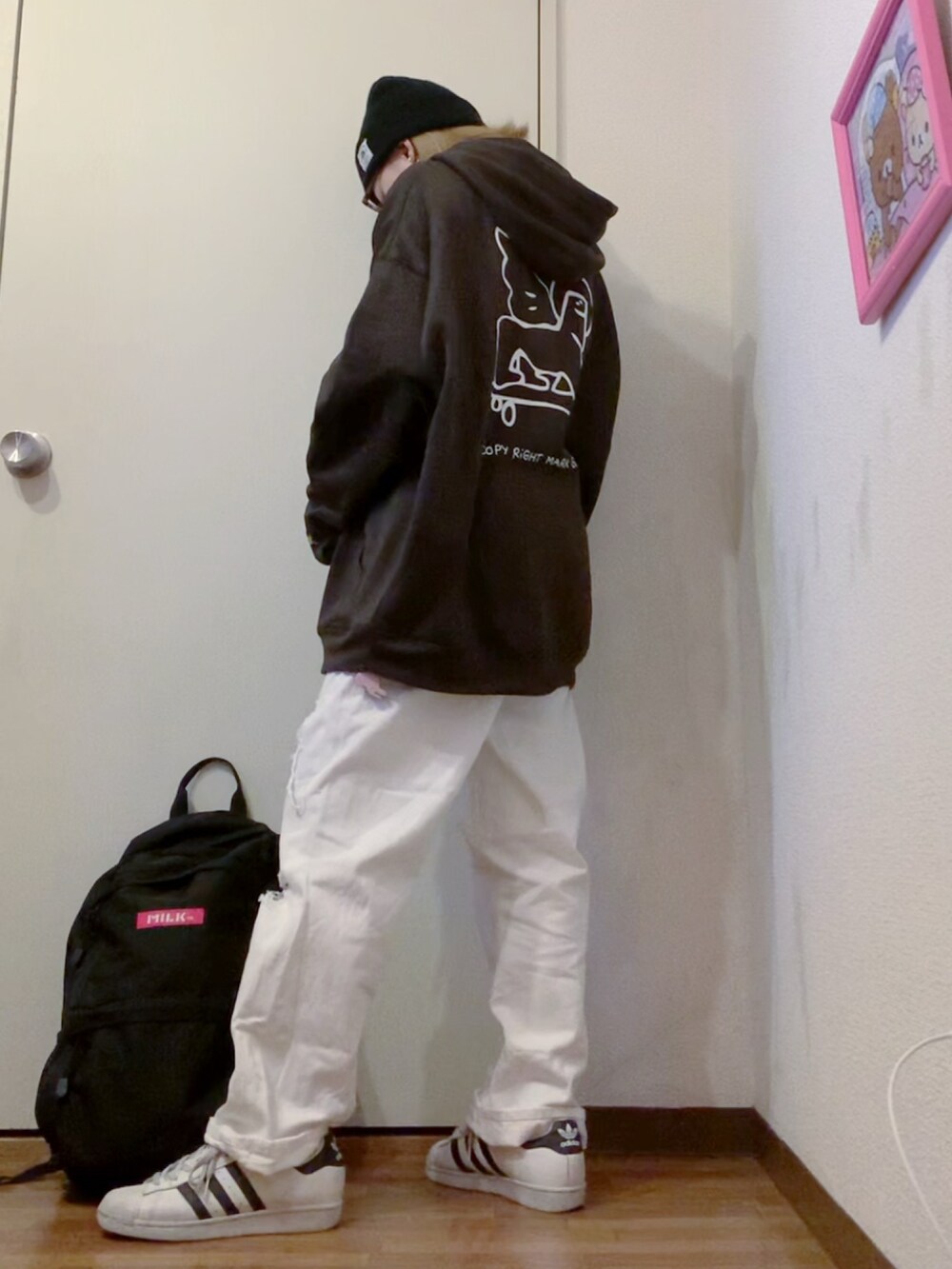 ブラック系のパーカー、ホワイト系のデニムパンツ、ホワイト系のニット/セーターを着用したレディースの冬コーディネートの2枚目の写真