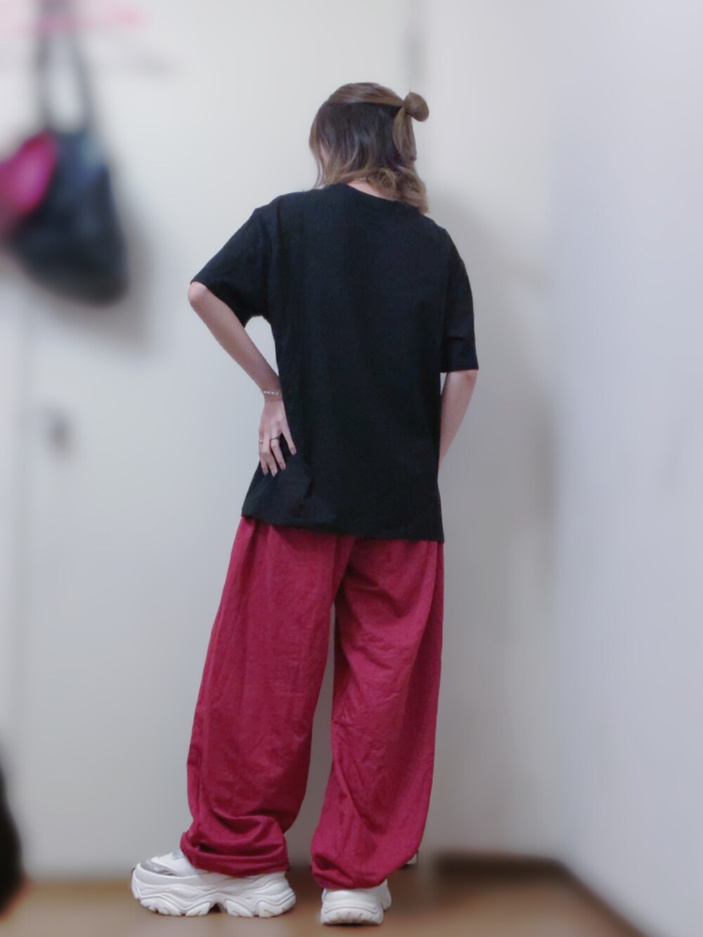 ブラック系のTシャツ/カットソー、レッド系のパンツ、ホワイト系のスニーカーを着用したレディースの春コーディネートの2枚目の写真