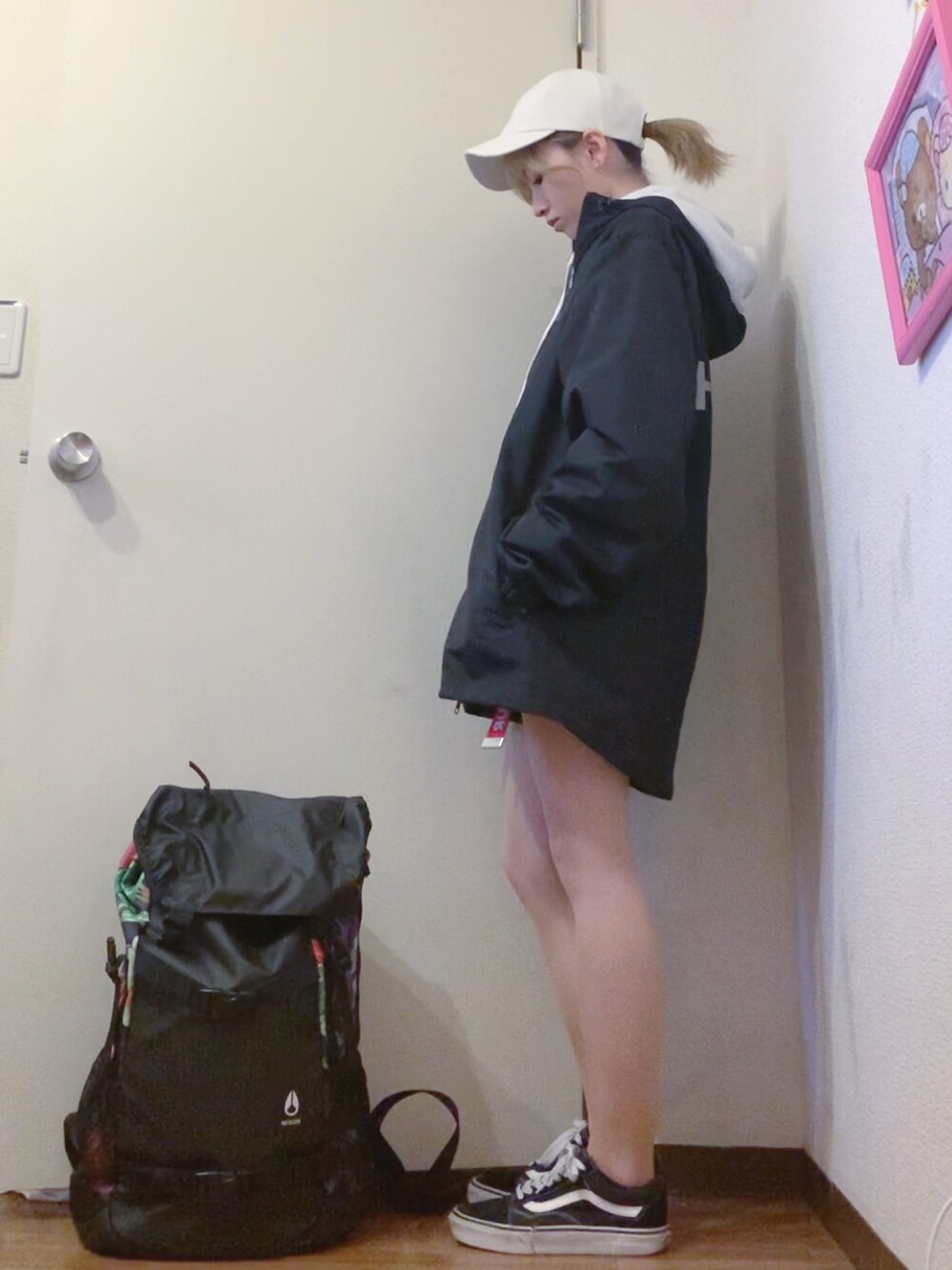 ブラック系のナイロンジャケット、グレー系のパーカー、ブラック系のデニムパンツを着用したレディースの春コーディネートの3枚目の写真