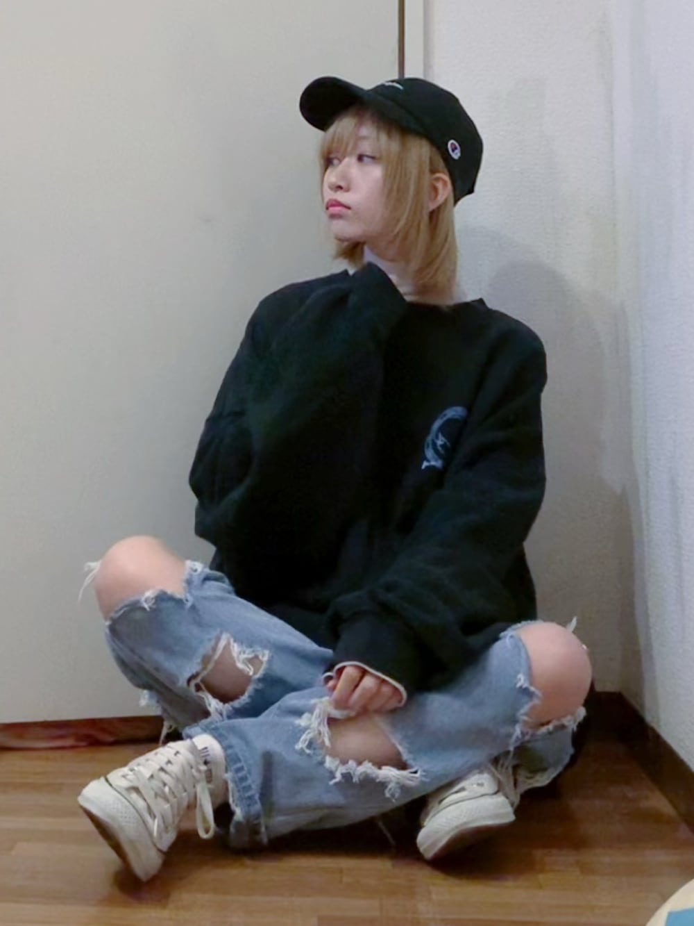 ブラック系のスウェット、ホワイト系のニット/セーター、ブルー系のデニムパンツを着用したレディースの冬コーディネートの2枚目の写真