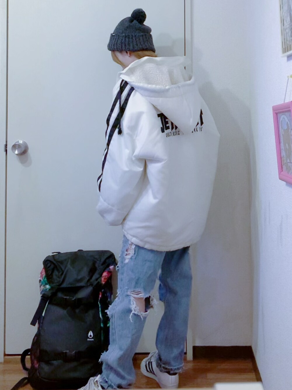 ホワイト系のスウェット、ホワイト系のブルゾン、ブルー系のデニムパンツを着用したレディースの秋コーディネートの2枚目の写真