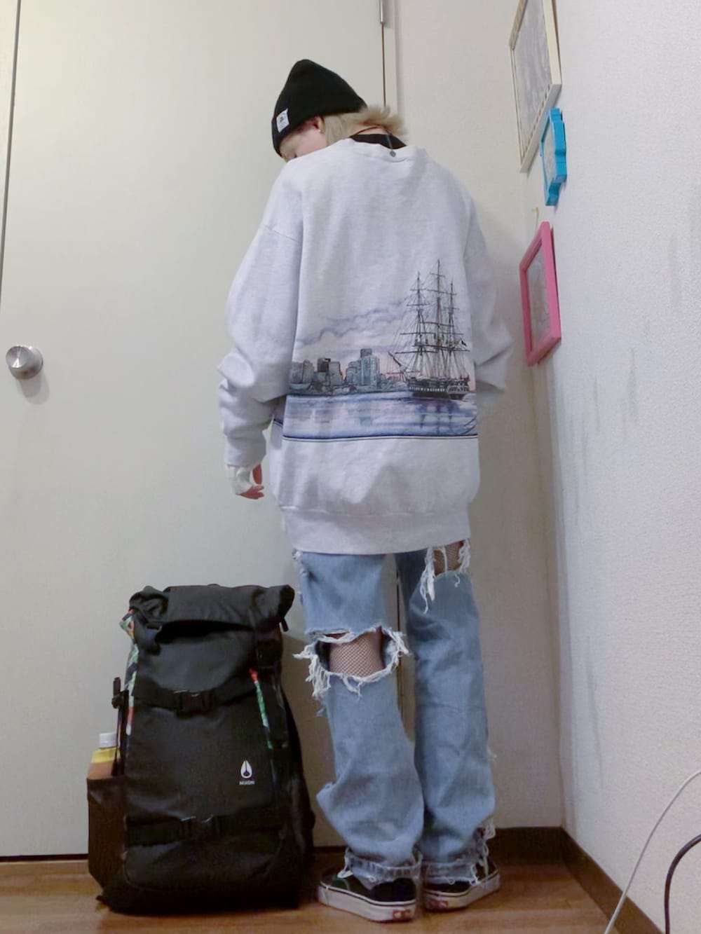 グレー系のスウェット、ブルー系のデニムパンツ、ブラック系のスニーカーを着用したレディースの秋コーディネートの3枚目の写真