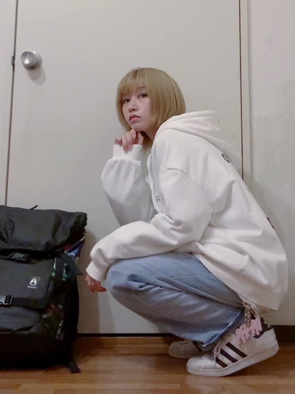 ホワイト系のパーカー、ホワイト系のスウェット、ブルー系のデニムパンツを着用したレディースの冬コーディネートの3枚目の写真