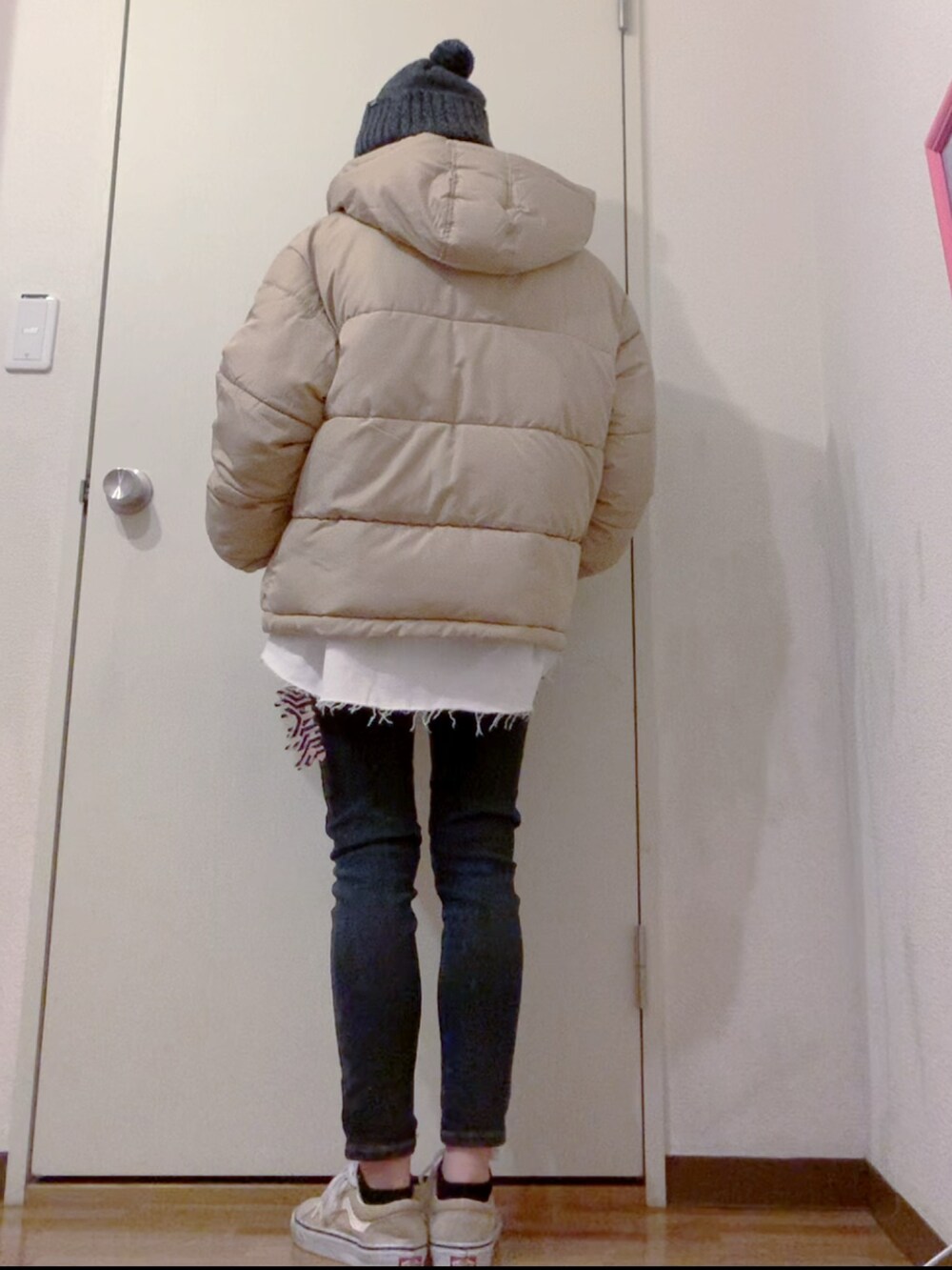 ホワイト系のスウェット、ブラック系のデニムパンツ、ベージュ系のダウンジャケット/コートを着用したレディースの冬コーディネートの5枚目の写真