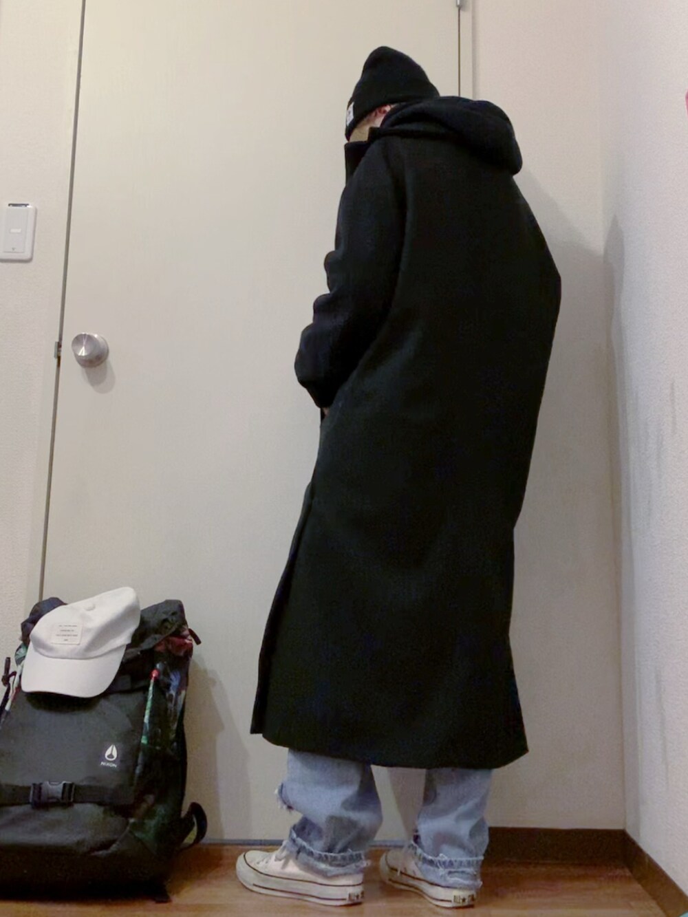 ブラック系のパーカー、ブルー系のデニムパンツ、ホワイト系のスニーカーを着用したレディースの冬コーディネートの4枚目の写真