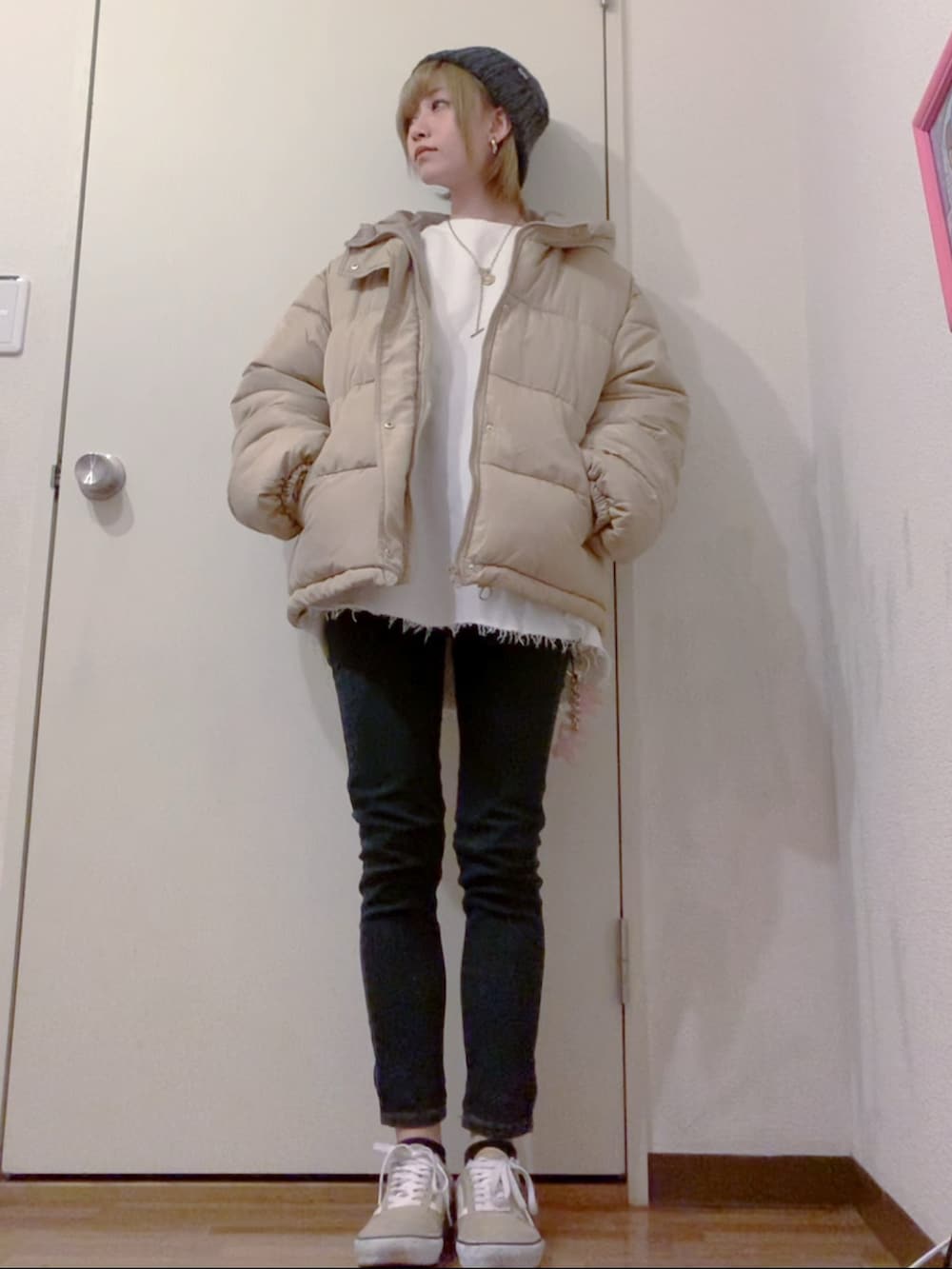 ホワイト系のスウェット、ブラック系のデニムパンツ、ベージュ系のダウンジャケット/コートを着用したレディースの冬コーディネートの2枚目の写真