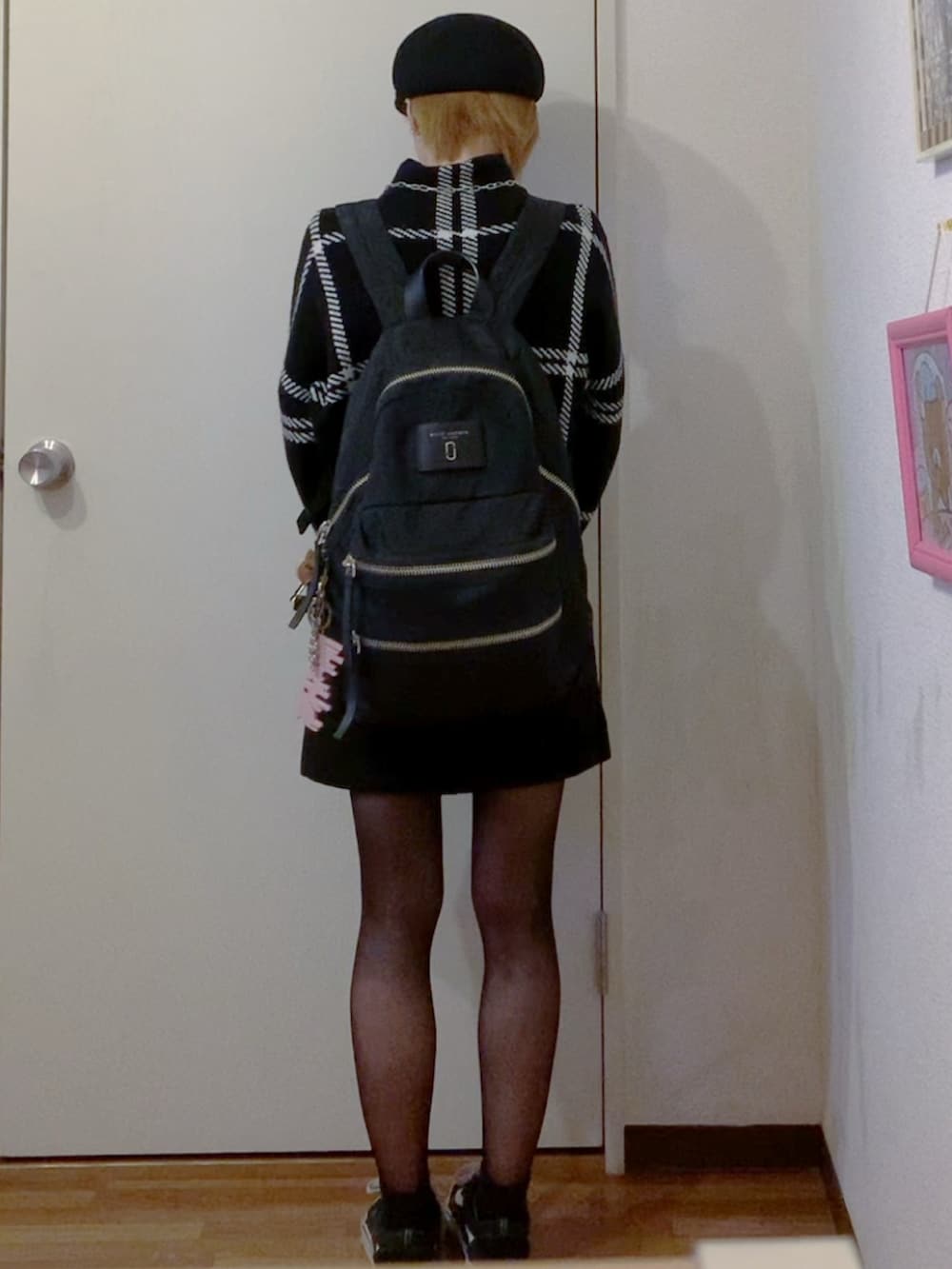 ブラック系のニット/セーター、ブラック系のスカート、ブラック系のスニーカーを着用したレディースの秋コーディネートの3枚目の写真