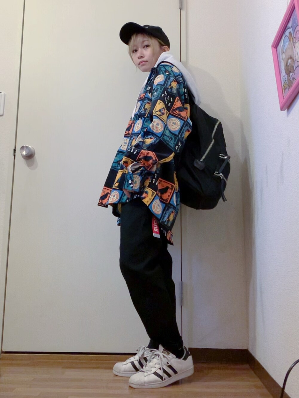 ブラック系のシャツ/ブラウス、グレー系のパーカー、ブラック系のデニムパンツを着用したレディースの春コーディネートの4枚目の写真