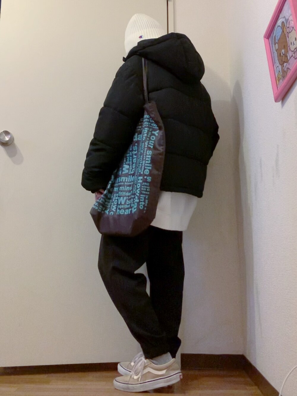 ホワイト系のニット/セーター、ホワイト系のスウェット、ブラック系のダウンジャケット/コートを着用したレディースの冬コーディネートの2枚目の写真