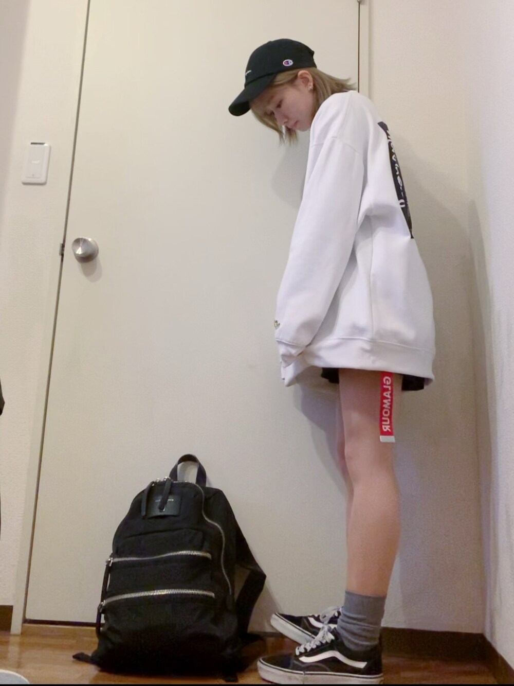 ホワイト系のスウェット、ブラック系のデニムパンツ、ブラック系のスニーカーを着用したレディースの冬コーディネートの2枚目の写真