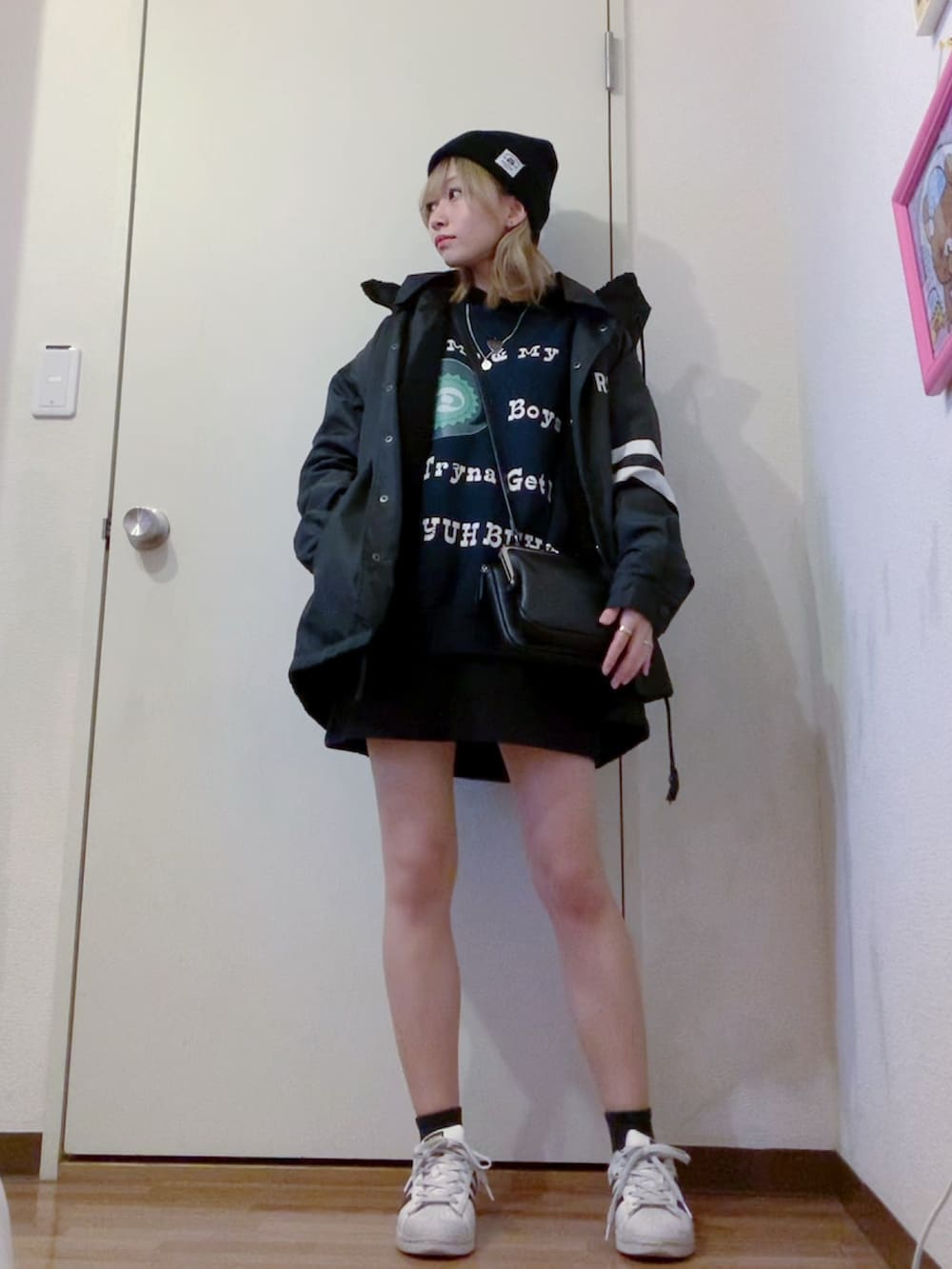 ブラック系のスウェット、ブラック系のスカート、ブラック系のナイロンジャケットを着用したレディースの春コーディネートの5枚目の写真
