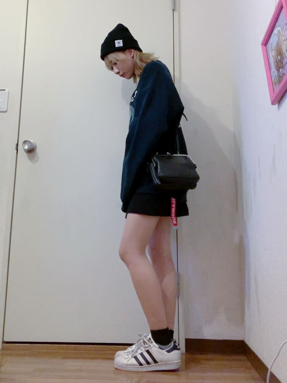 ブラック系のスウェット、ブラック系のスカート、ブラック系のナイロンジャケットを着用したレディースの春コーディネートの4枚目の写真