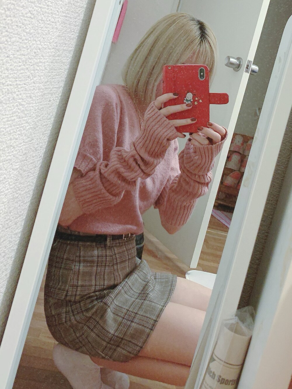 ピンク系のニット/セーター、ブラウン系のスカート、ベージュ系のスニーカーを着用したレディースの秋コーディネートの2枚目の写真