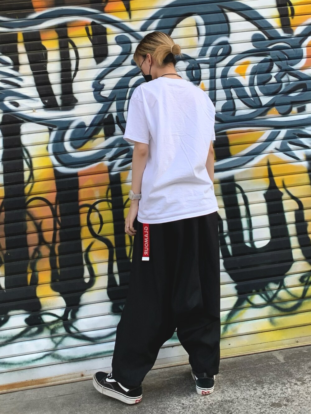 ホワイト系のTシャツ/カットソー、ブラック系のその他パンツ、ブラック系のスニーカーを着用したレディースの春コーディネートの2枚目の写真