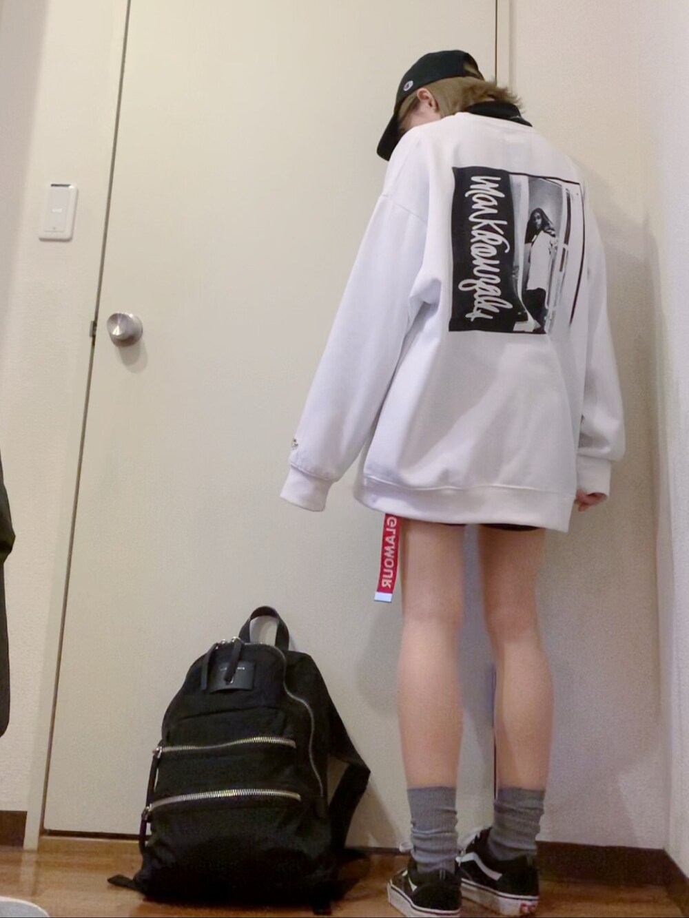 ホワイト系のスウェット、ブラック系のデニムパンツ、ブラック系のスニーカーを着用したレディースの冬コーディネートの3枚目の写真