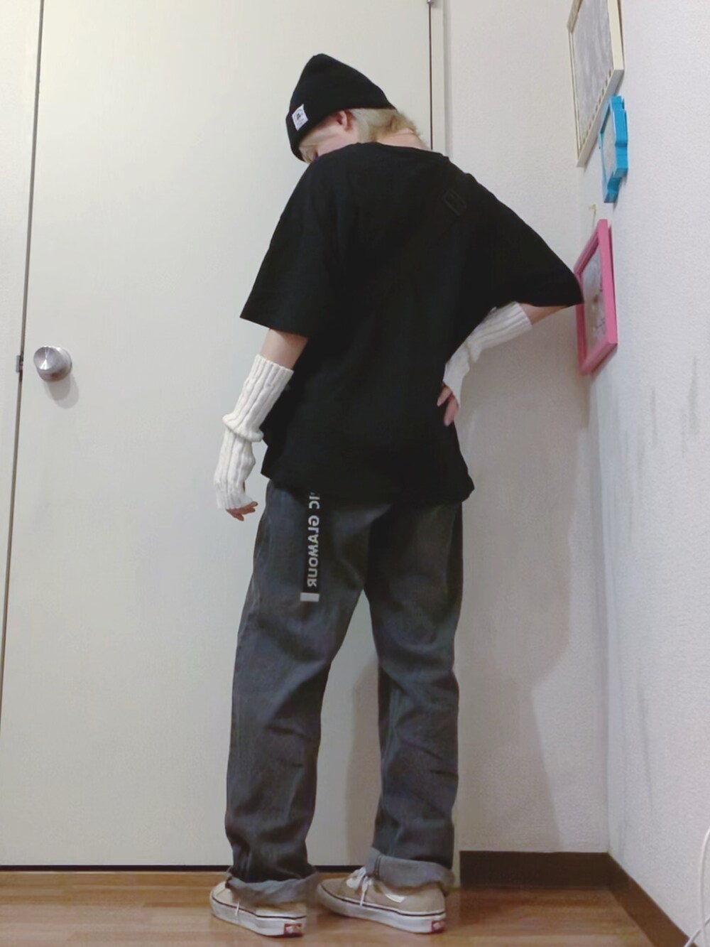 ブラック系のTシャツ/カットソー、ブラック系のデニムパンツ、ベージュ系のスニーカーを着用したレディースの秋コーディネートの3枚目の写真