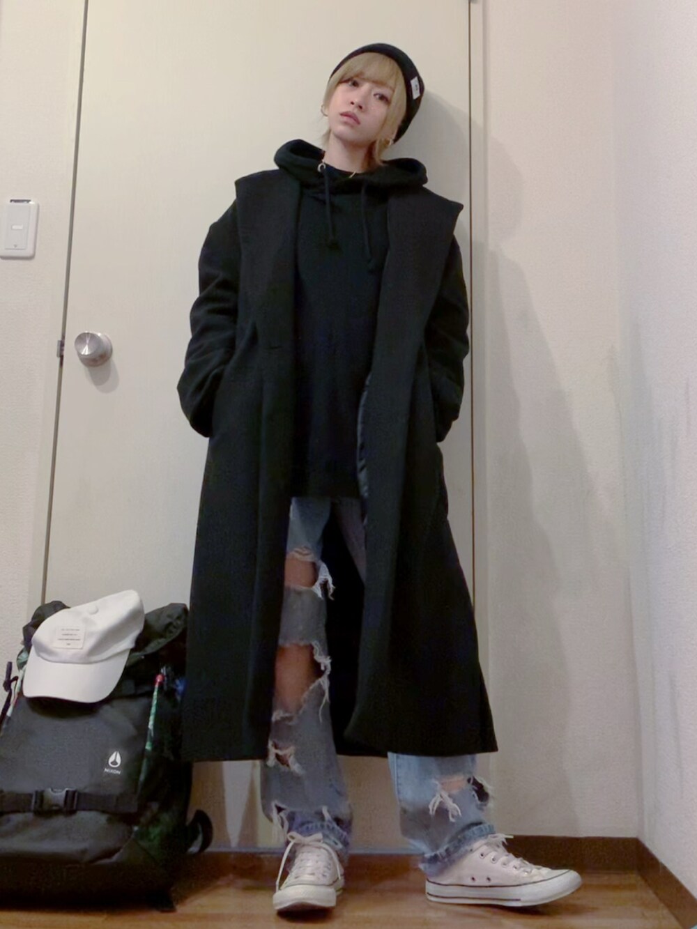 ブラック系のパーカー、ブルー系のデニムパンツ、ホワイト系のスニーカーを着用したレディースの冬コーディネートの2枚目の写真