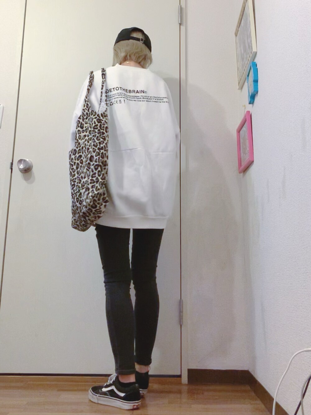 ホワイト系のスウェット、ブラック系のデニムパンツ、ブラック系のスニーカーを着用したレディースの秋コーディネートの3枚目の写真