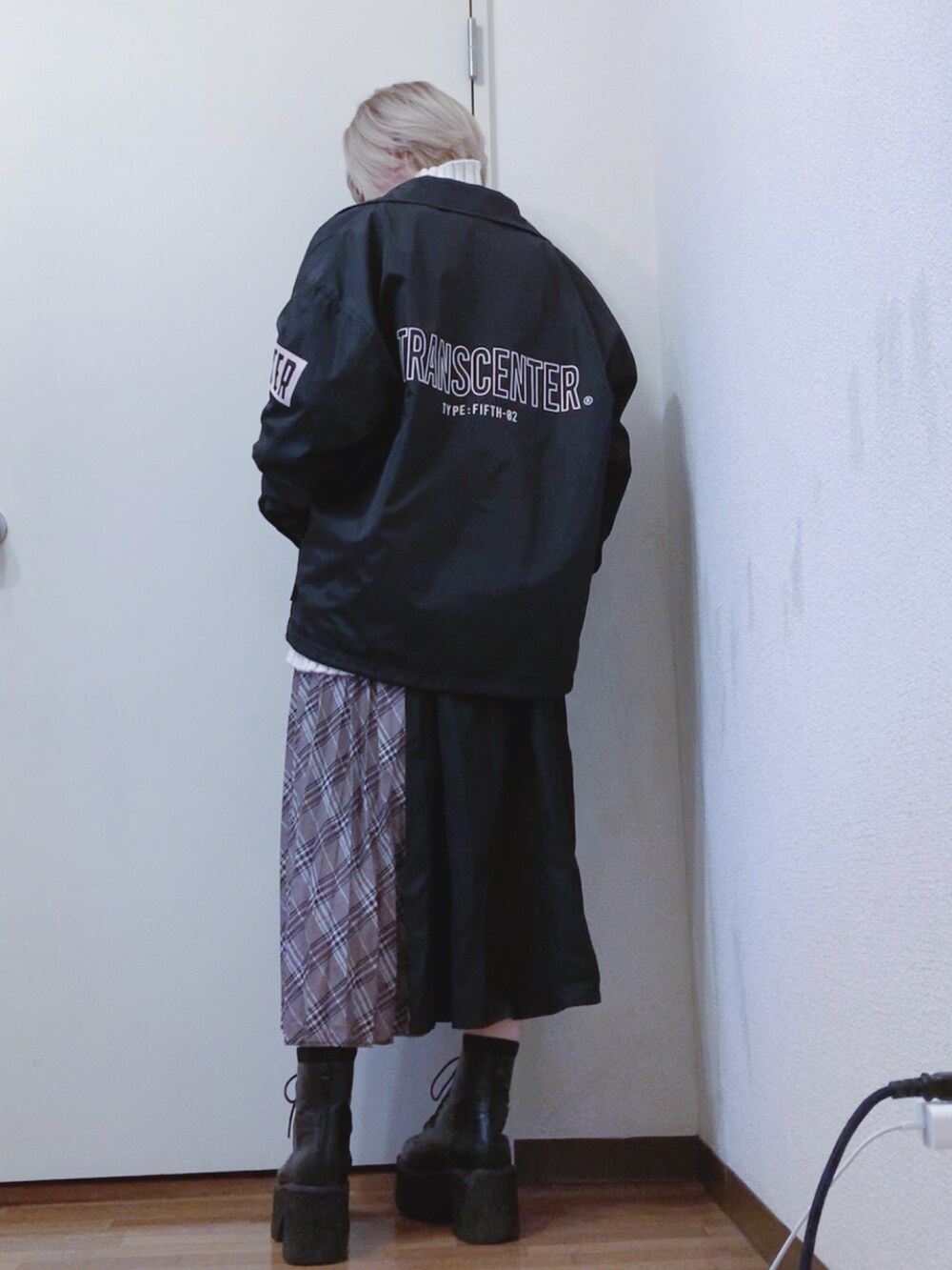 ホワイト系のニット/セーター、ブラック系のナイロンジャケット、ブラック系のスカートを着用したレディースの春コーディネートの2枚目の写真