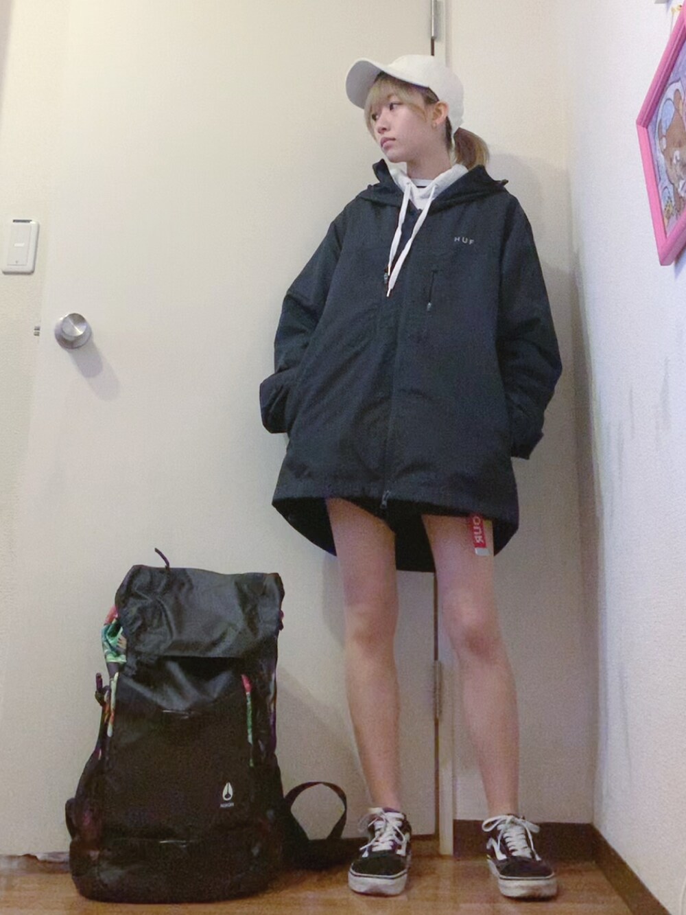 ブラック系のナイロンジャケット、グレー系のパーカー、ブラック系のデニムパンツを着用したレディースの春コーディネートの2枚目の写真