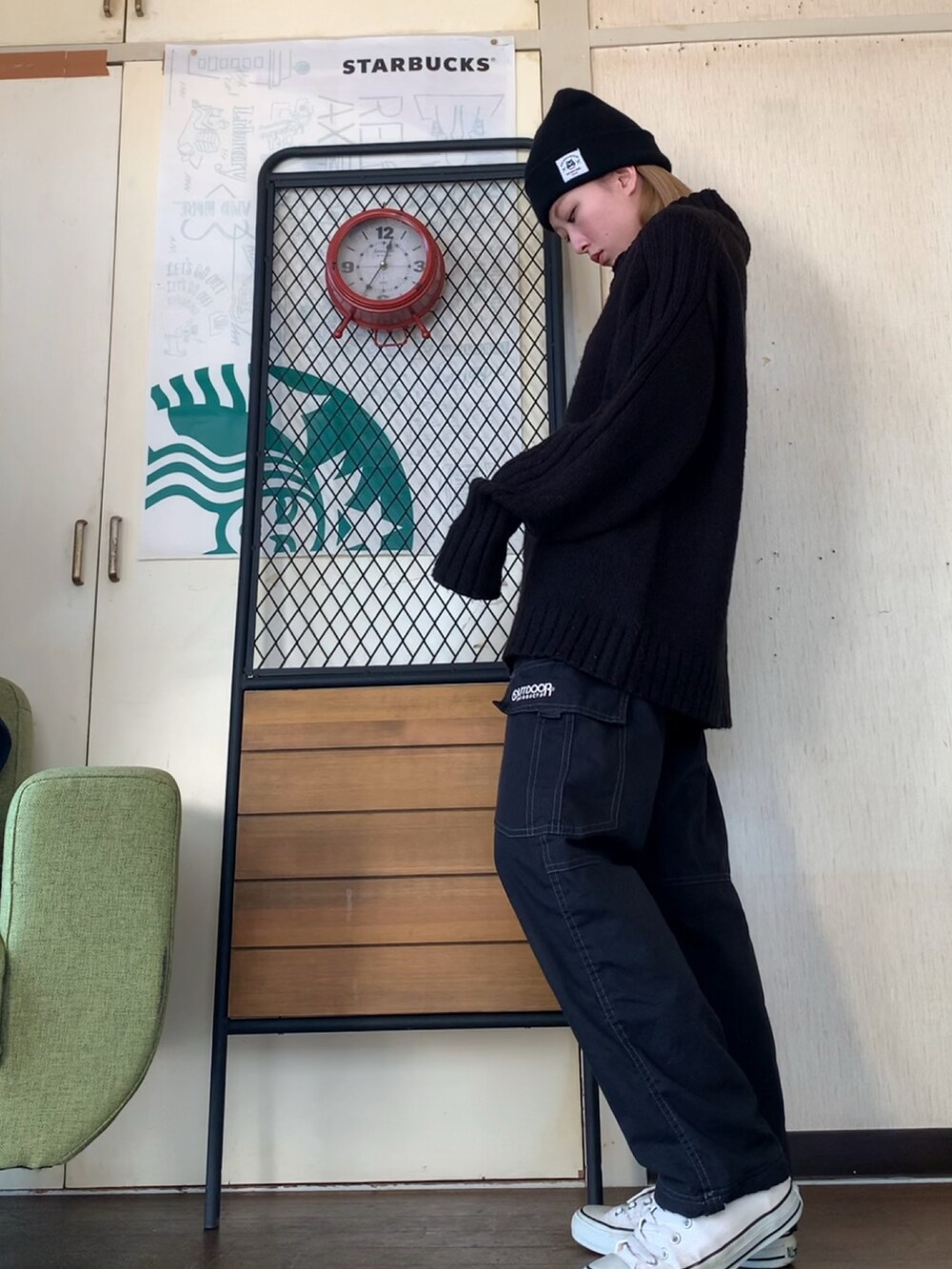 ブラック系のニット/セーター、ブラック系のカーゴパンツ、ベージュ系のダウンジャケット/コートを着用したレディースの冬コーディネートの3枚目の写真