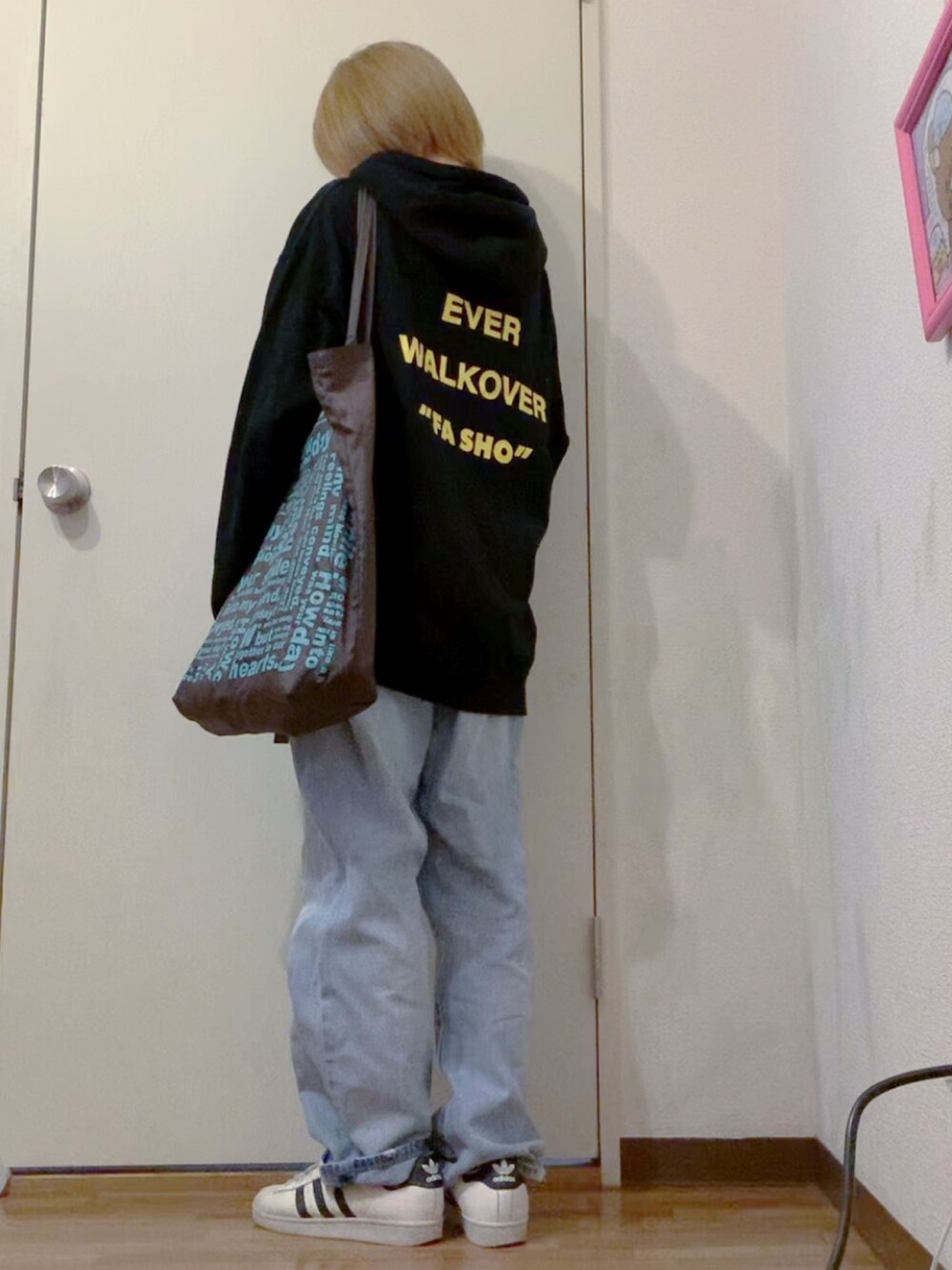 ブラック系のパーカー、ブルー系のデニムパンツ、ブラック系のナイロンジャケットを着用したレディースの冬コーディネートの4枚目の写真