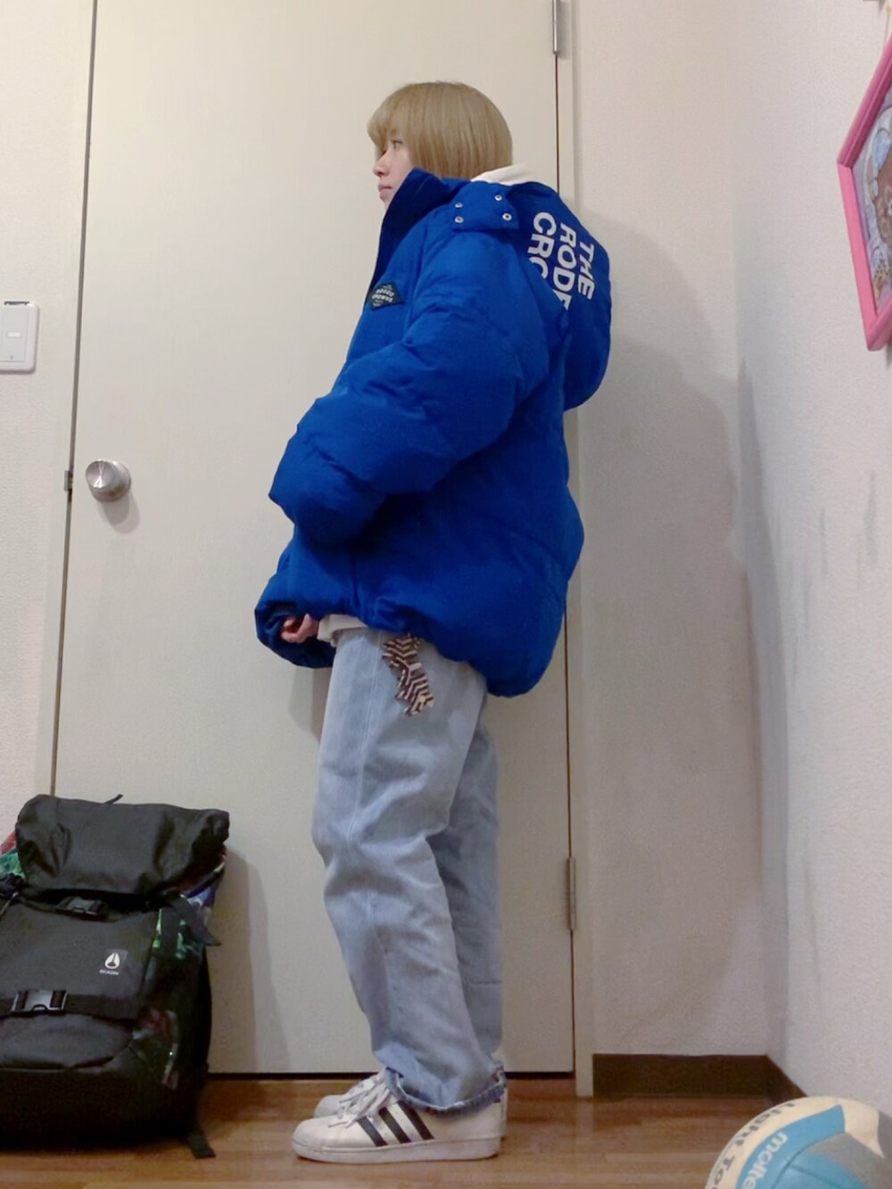 ホワイト系のパーカー、ホワイト系のスウェット、ブルー系のデニムパンツを着用したレディースの冬コーディネートの2枚目の写真