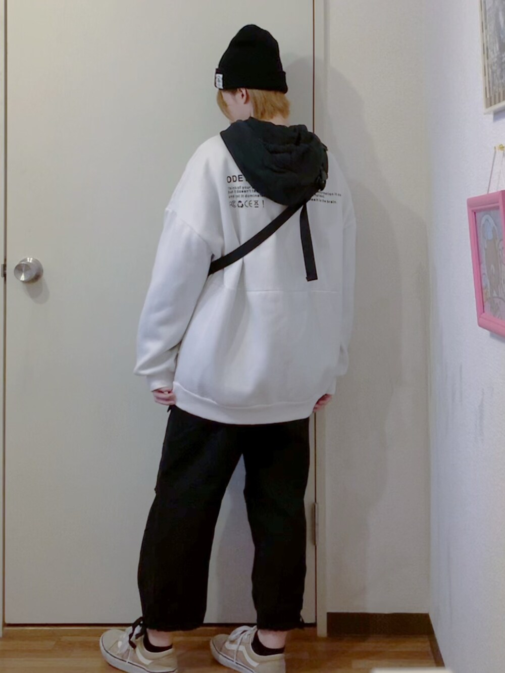 ホワイト系のスウェット、ブラック系のパーカー、ブラック系のカーゴパンツを着用したレディースの秋コーディネートの4枚目の写真