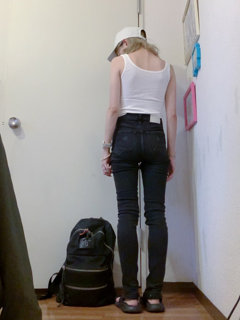 ホワイト系のタンクトップ、ブラック系のサンダル、ブラック系のバックパック/リュックを着用したレディースの夏コーディネートの2枚目の写真