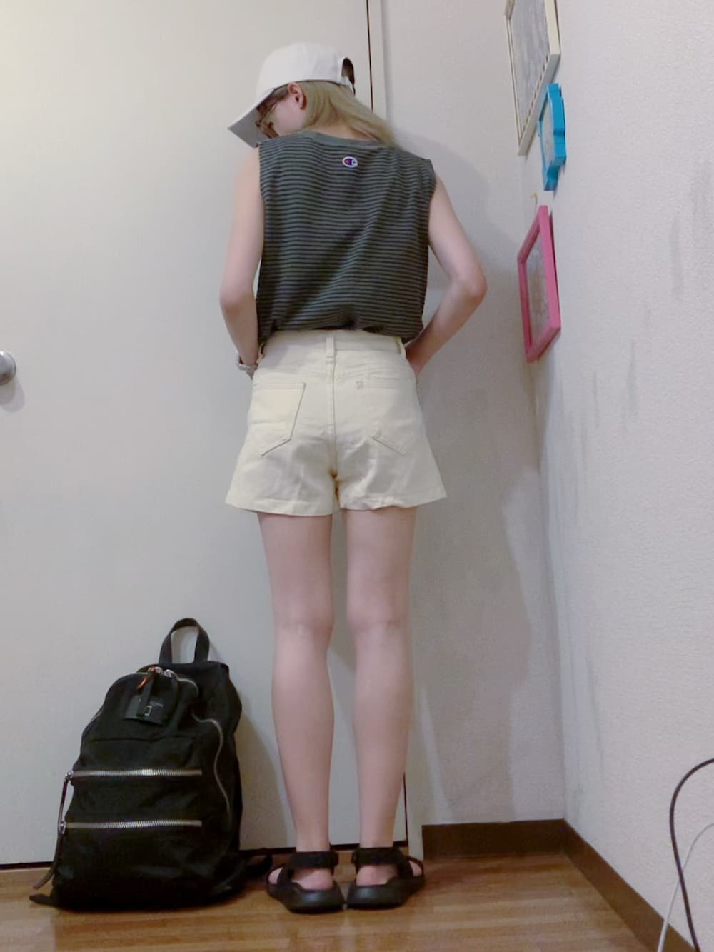 グレー系のタンクトップ、ホワイト系のデニムパンツ、ブラック系のサンダルを着用したレディースの夏コーディネートの2枚目の写真